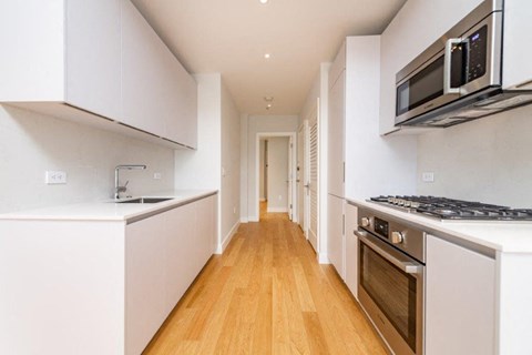 a kitchen with white cabinets and a stove and a microwave
